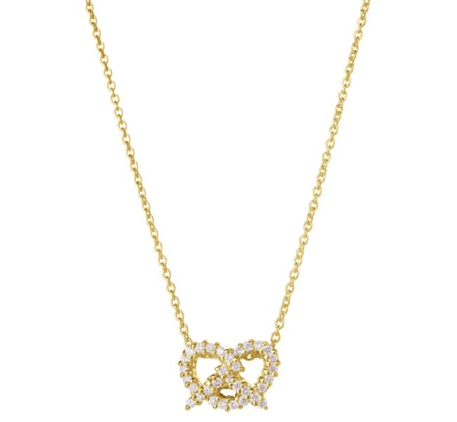 A delicate gold chain necklace featuring a pendant composed of pretzel each adorned with small clear stones, set against a plain white background.
