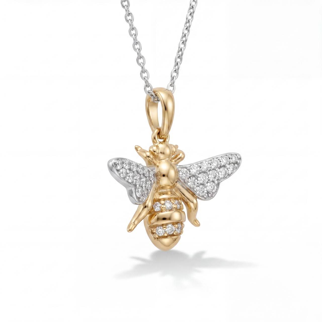 Gold bee pendant necklace with diamond accents on a white background
