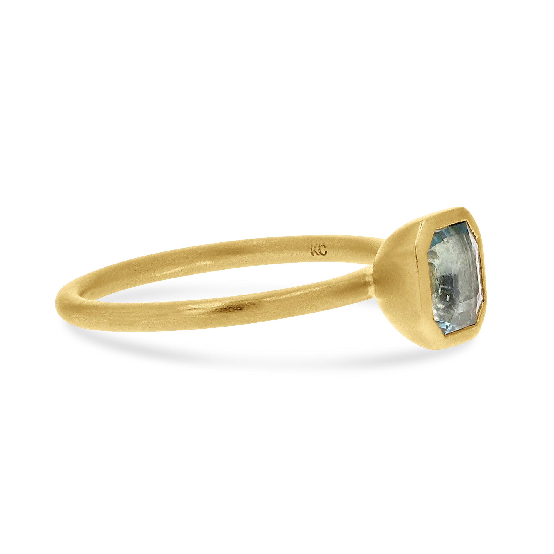 Gold ring with a blue gemstone on a white background