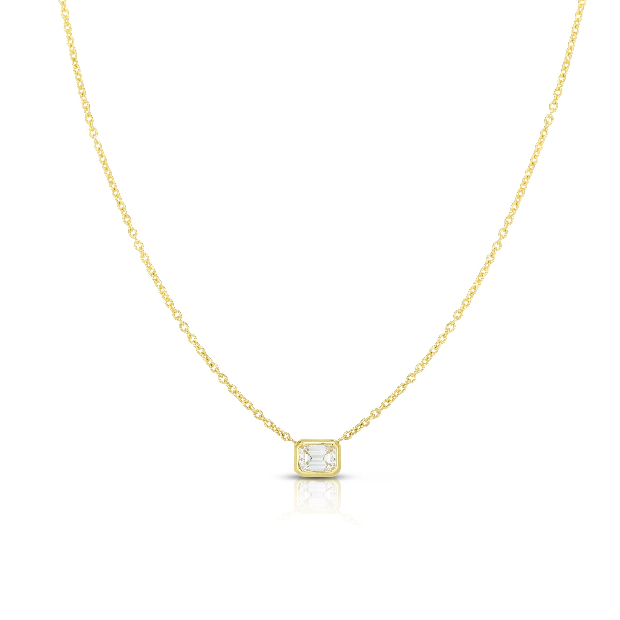 A front view of the Roberto Coin Diamonds by the Inch Emerald Cut Solitaire Necklace (SKU 111365AYCHX0) in 18k yellow gold, showcasing a horizontally oriented, step-cut rectangular diamond inside a sleek protective single bezel setting, suspended from a delicate fine gold link chain against a white background.