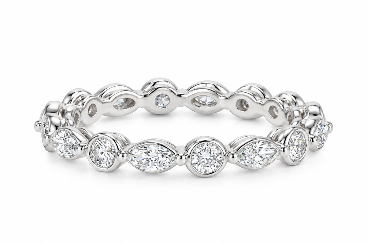A white gold eternity band ring featuring marquise-cut and round brilliant-cut diamonds, set against a clean white background.