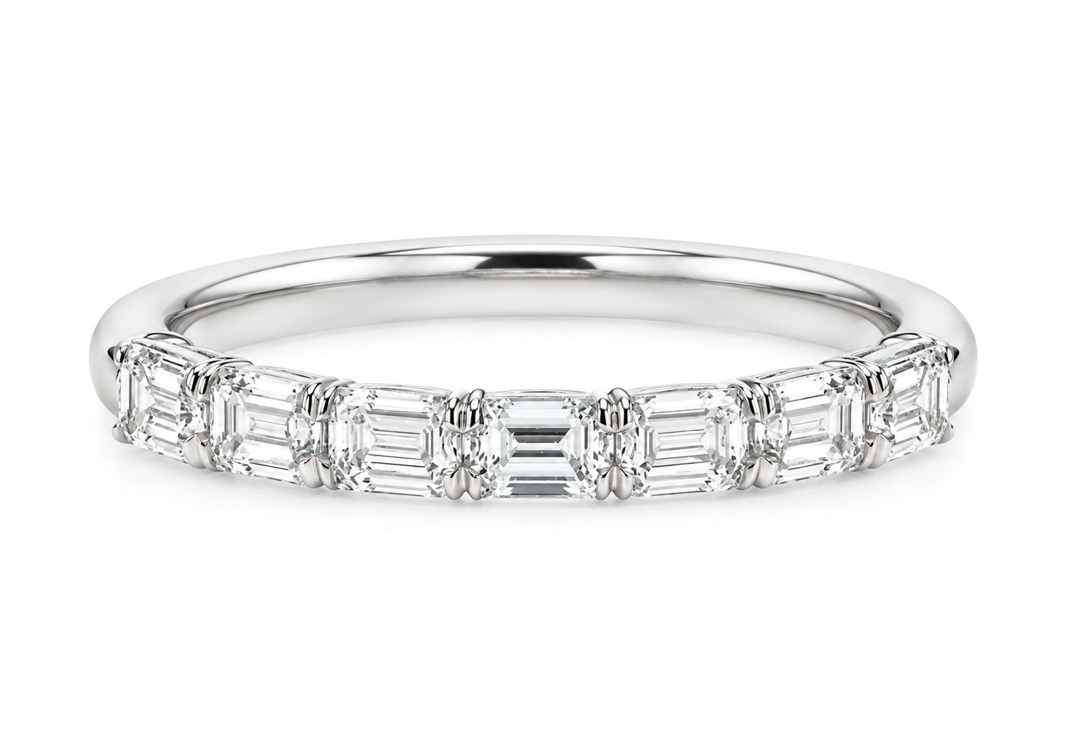 A white diamond band ring featuring a row of emerald-cut diamonds set in a polished silver-colored metal, shown against a plain white background.