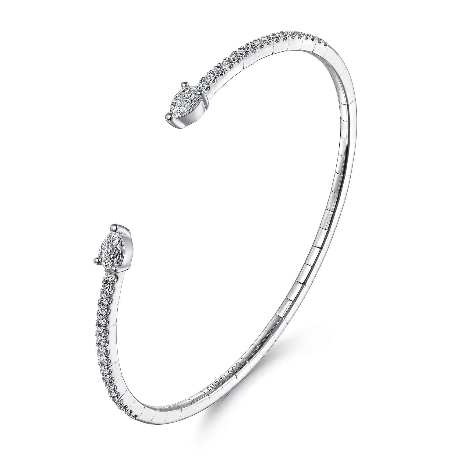 A white gold open cuff bangle bracelet with pavé-set clear stones along the outer curve and pear shaped stones at both ends, shown on a clean white background.
