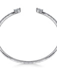 A white gold open bangle bracelet with a row of small pavé-set stones along the band and a larger central stone at each end, shown on a plain white background. side view