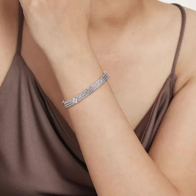 white gold  bracelet on a person wearing a brown top