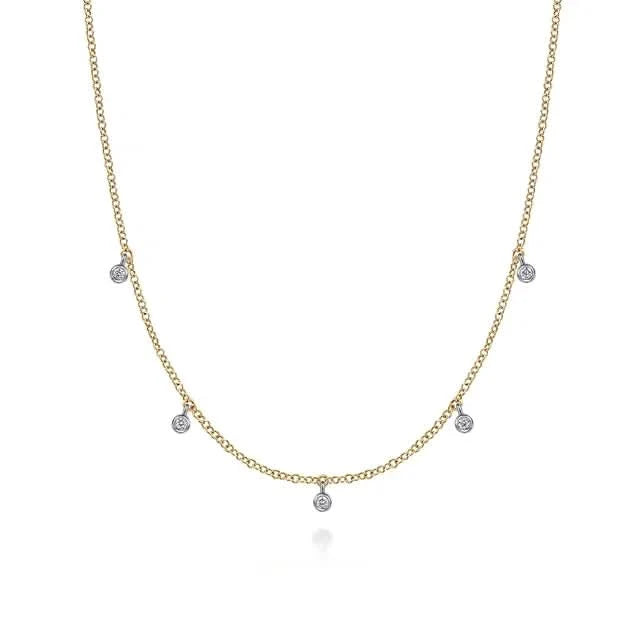 Gold necklace with small diamond droplets on a white background