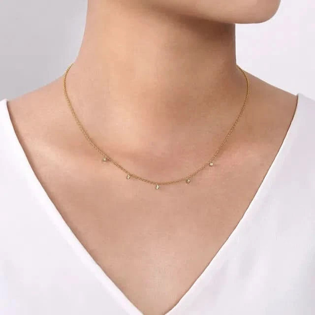 Gold necklace on a model against a neutral background