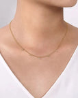 Gold necklace on a model against a neutral background