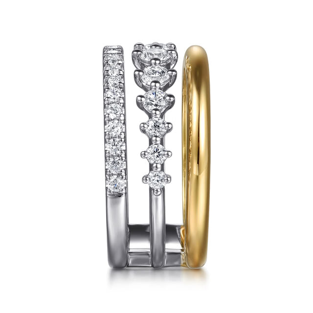 A three stacked rings shown from the side on a white background. two are white gold with a pavé diamond band, and the other is plain yellow gold side view