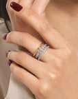 Close-up of a hand wearing a three stack ring with a neutral background