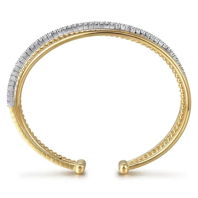Gold and silver bangle on a white background side view