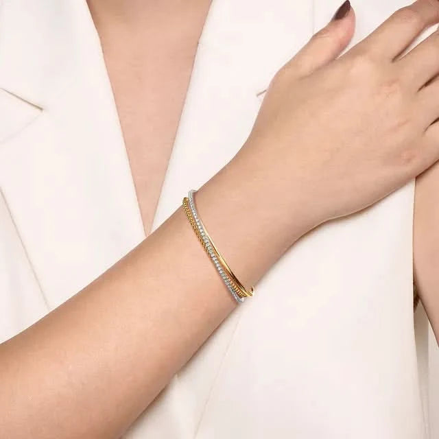 Gold bracelet on a person's wrist against a white background
