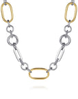 A two-tone chain necklace featuring polished silver-colored round and elongated links, accented by three gold-colored oval links, displayed on a clean white background. close up 