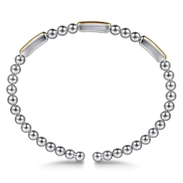 Silver beaded bracelet with gold accents on a white background side view