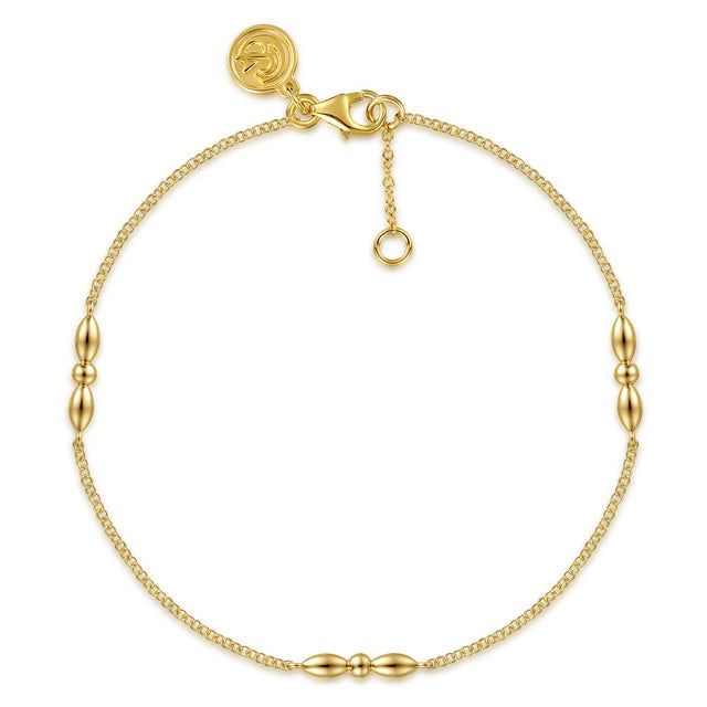 A delicate gold chain bracelet with three polished bead accents spaced along the chain, a lobster clasp, and an adjustable extender ring, shown on a plain white background.