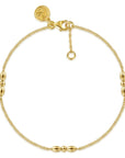 A delicate gold chain bracelet with three polished bead accents spaced along the chain, a lobster clasp, and an adjustable extender ring, shown on a plain white background.