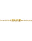 A delicate gold chain bracelet featuring a central decorative clasp with two elongated teardrop beads and a small central bead, shown against a plain white background.
