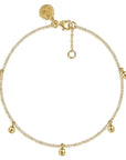 Gold bracelet with small gold balls on a white background