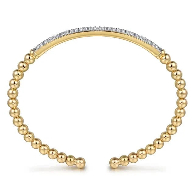 Gold beaded bracelet with a diamond-studded band on a white background side view