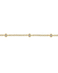 A delicate yellow gold chain bracelet featuring three small bezel-set round clear gemstones spaced evenly along the front, shown against a plain white background. close up