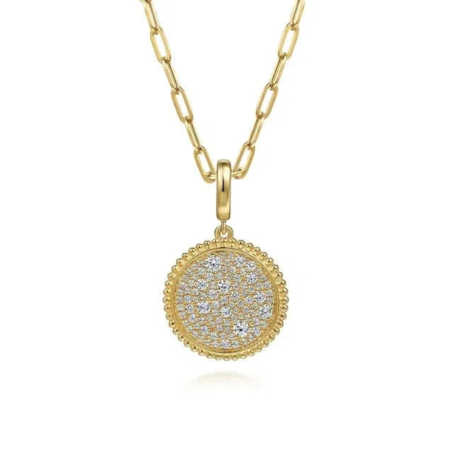Gold necklace with a round, diamond-studded pendant on a white background