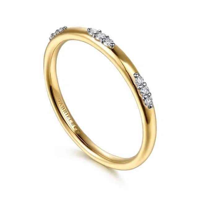 Gold ring with small diamonds on a white background angled view