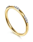 Gold ring with small diamonds on a white background angled view