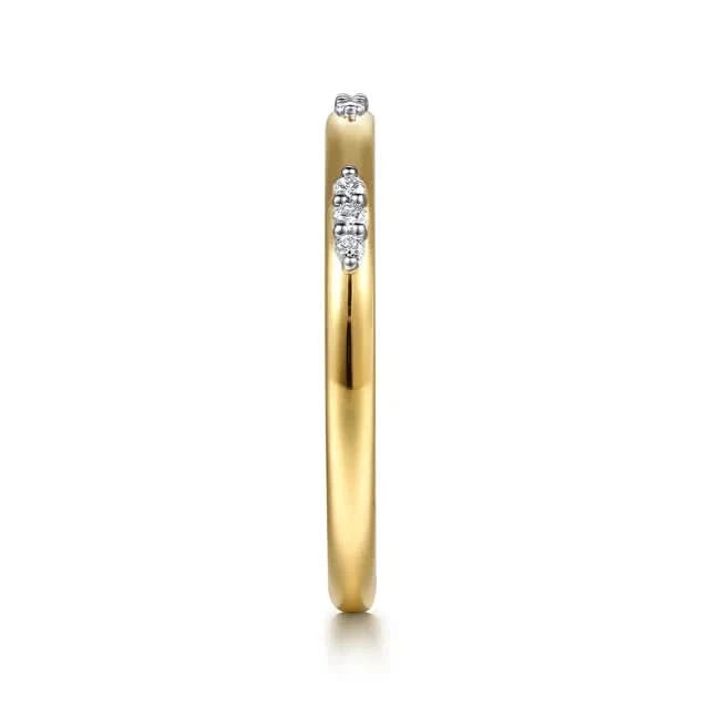 Gold ring with embedded diamonds on a white background side view