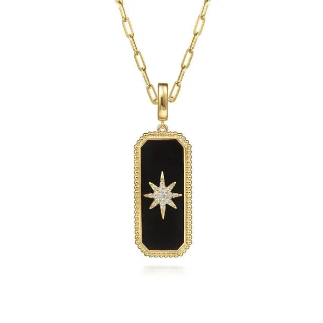 Gold necklace with a black onyx pendant featuring a star design on a white background