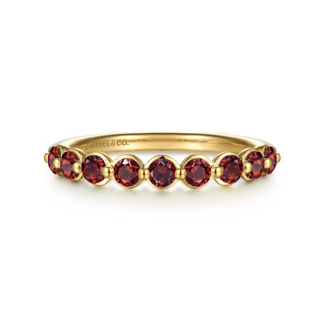 A yellow gold  ring featuring nine round-cut red garnet gemstones, shown on a clean white background. The brand name 'GABRIEL &amp; CO.