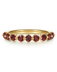 A yellow gold  ring featuring nine round-cut red garnet gemstones, shown on a clean white background. The brand name 'GABRIEL & CO.