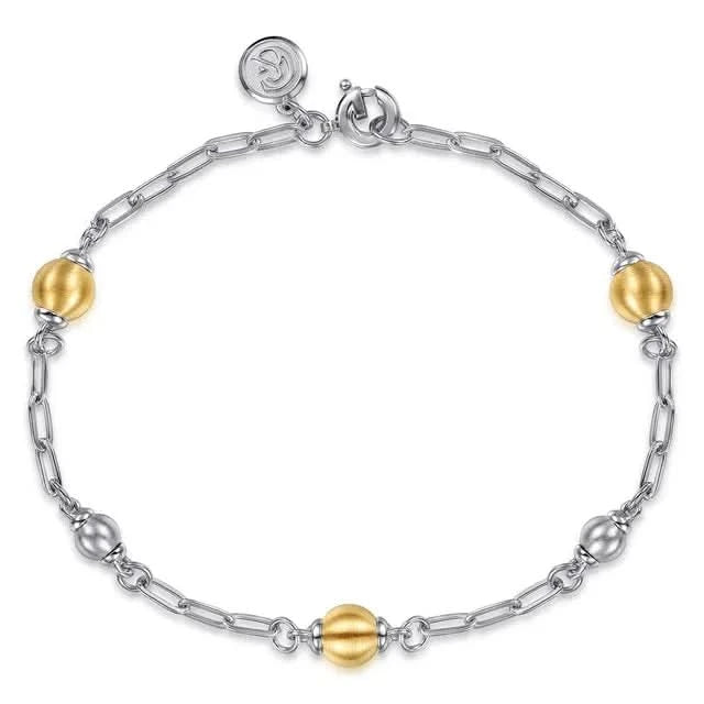 Bracelet with gold and silver beads on a white background