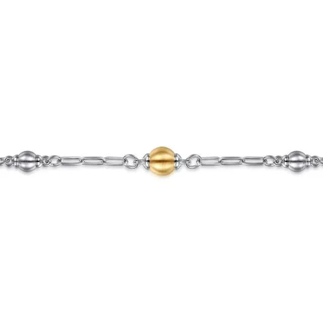 Gold and silver beaded bracelet on a white background close up