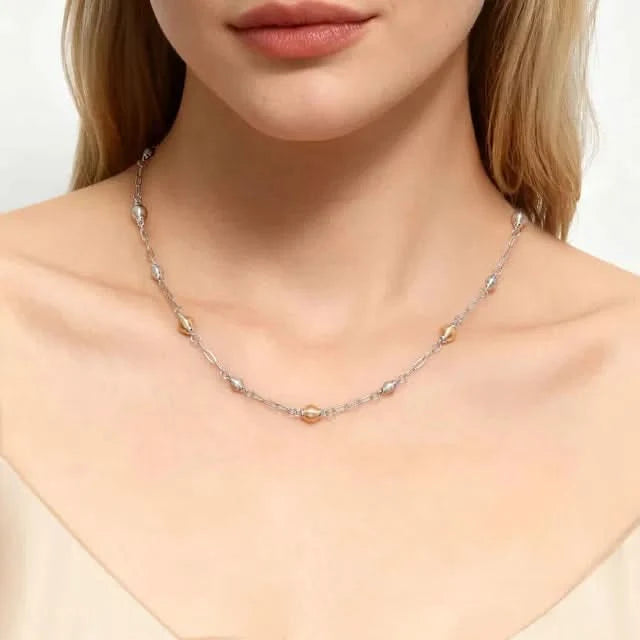 Necklace with small beads worn by a model on a neutral background