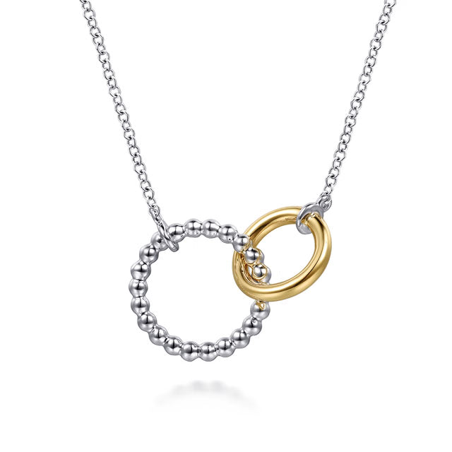 Necklace with interlocking rings, one gold and one silver, on a white background