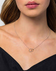 Necklace with interlocking rings worn by a model against a neutral background