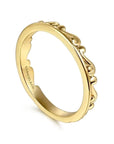 Gold ring with intricate design on a white background angled