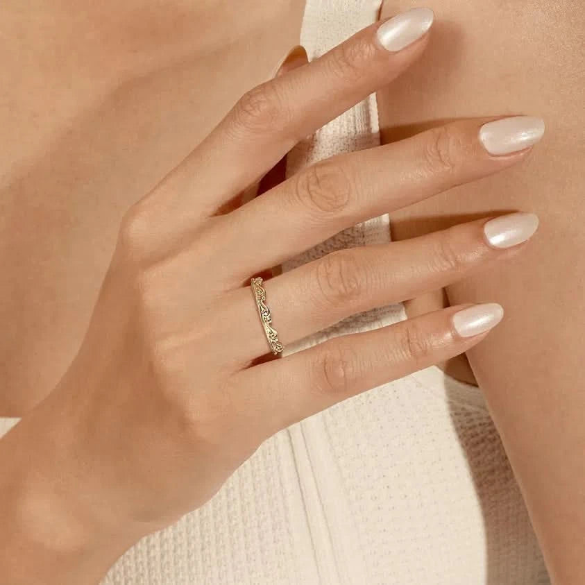 Close-up of a hand wearing a gold ring with a soft focus background