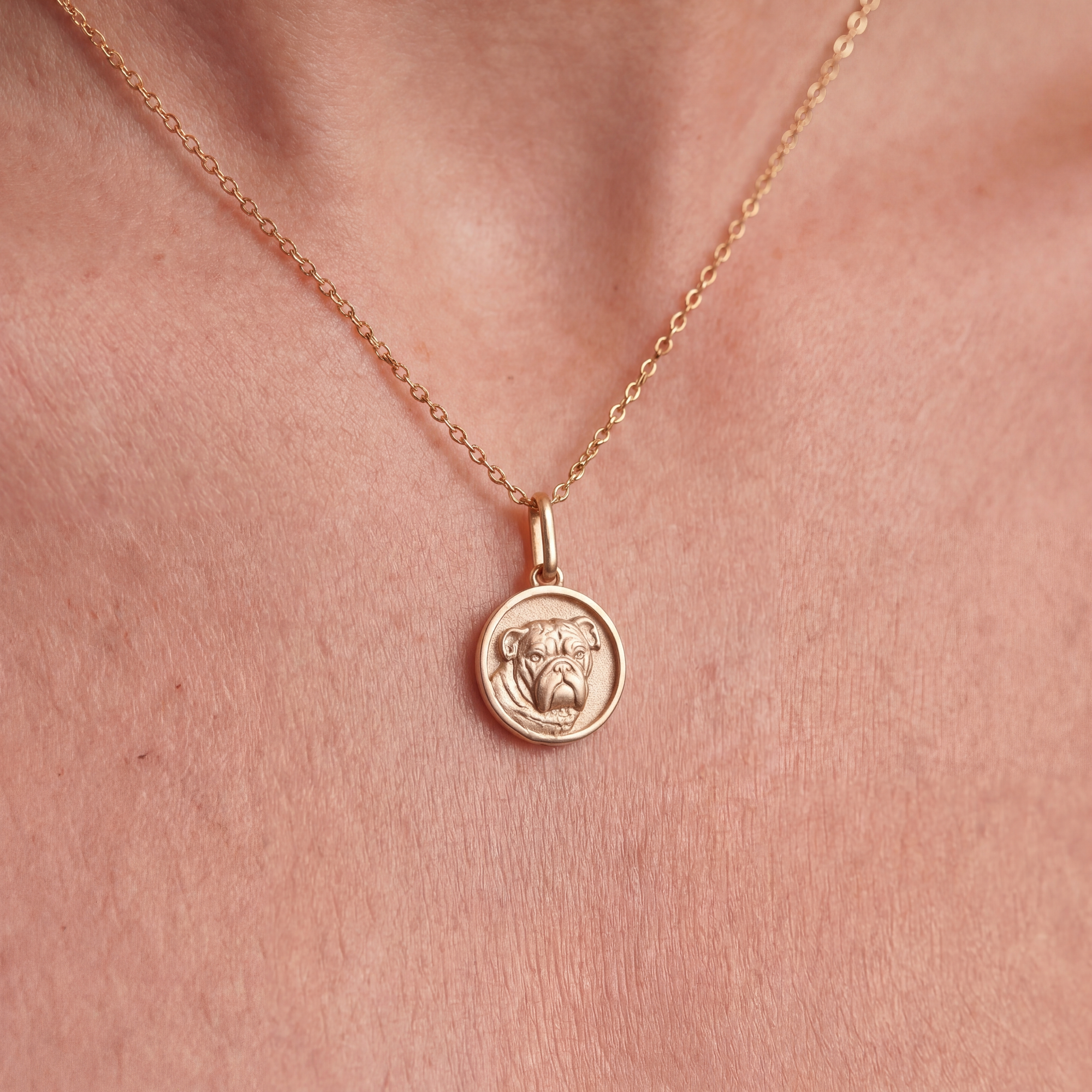 Gold chain with bulldog medallion on a person's neck
