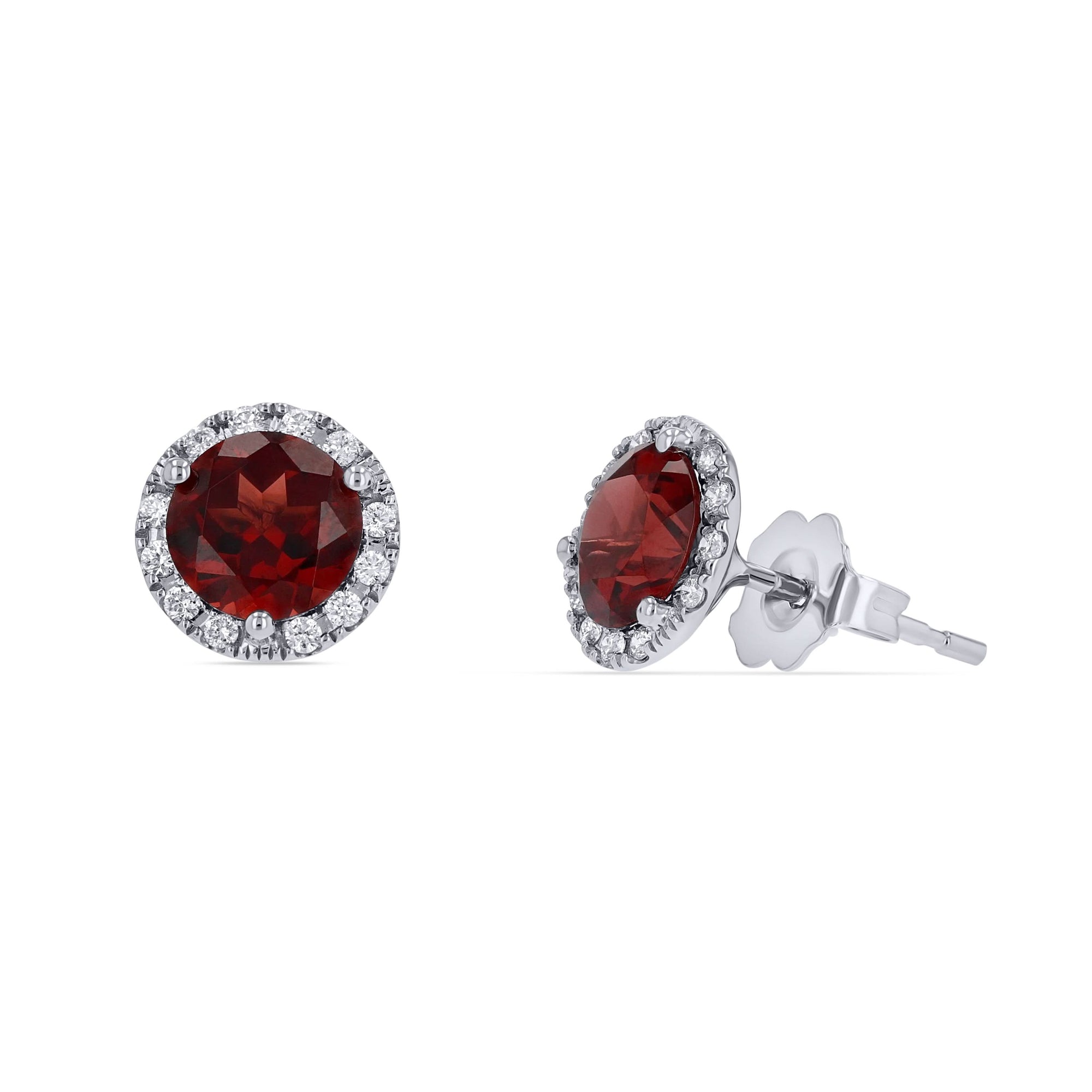 A pair of genuine 6mm round red garnet halo stud earrings framed by brilliant white diamonds in a 14k white gold setting, showing one front-facing view and one angled profile view with a friction post and scalloped backing on a white background.
