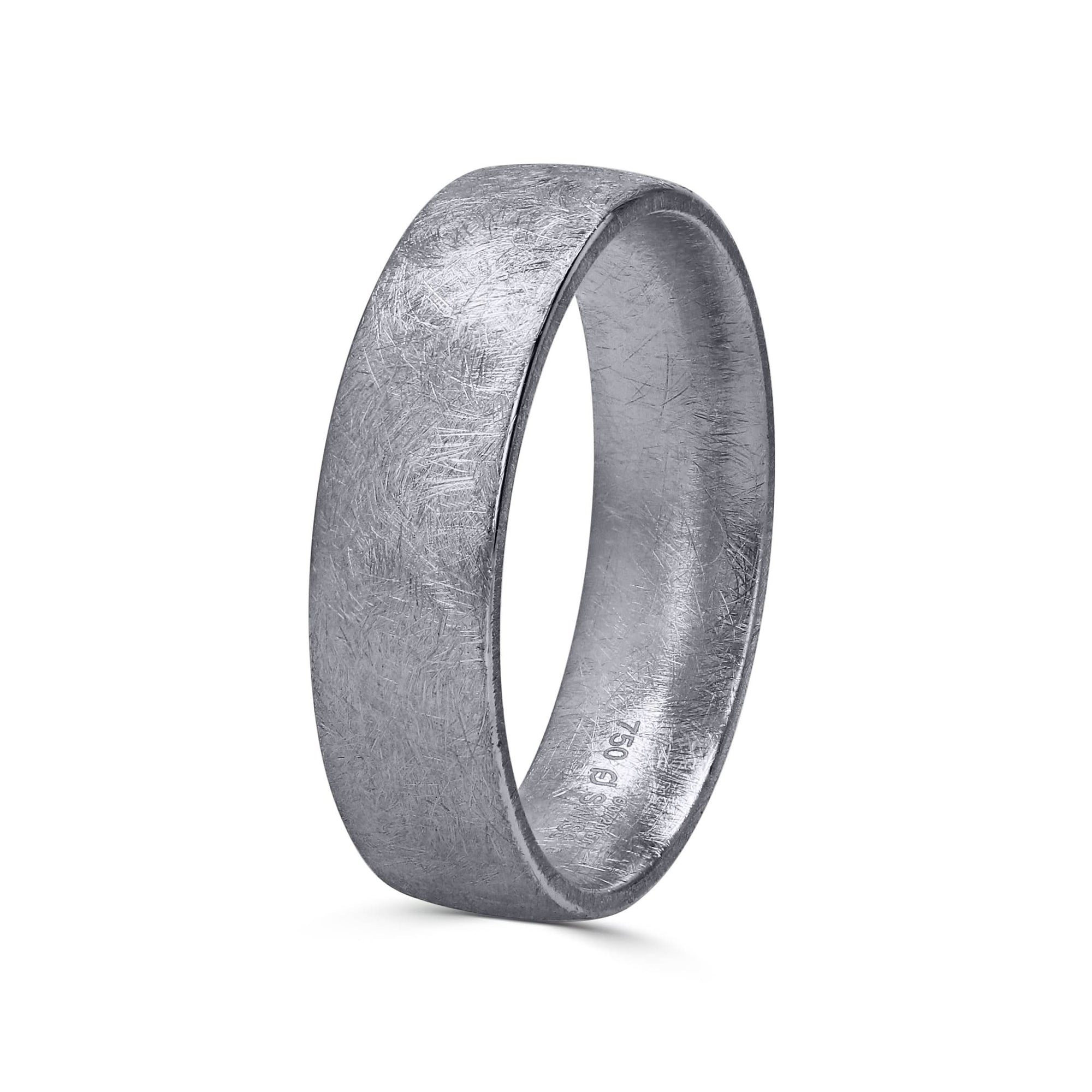 A 6mm men's wedding band by Furrer Jacot, crafted in solid 18k white gold and showcasing a distinctive, multi-directional matte brushed finish with an intricate cross-hatched texture.
 viewed at a side angle and upright position. 
