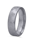 A 6mm men's wedding band by Furrer Jacot, crafted in solid 18k white gold and showcasing a distinctive, multi-directional matte brushed finish with an intricate cross-hatched texture.
 viewed at a side angle and upright position. 