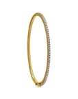 Gold bracelet with clear stones on a white background angled side profile