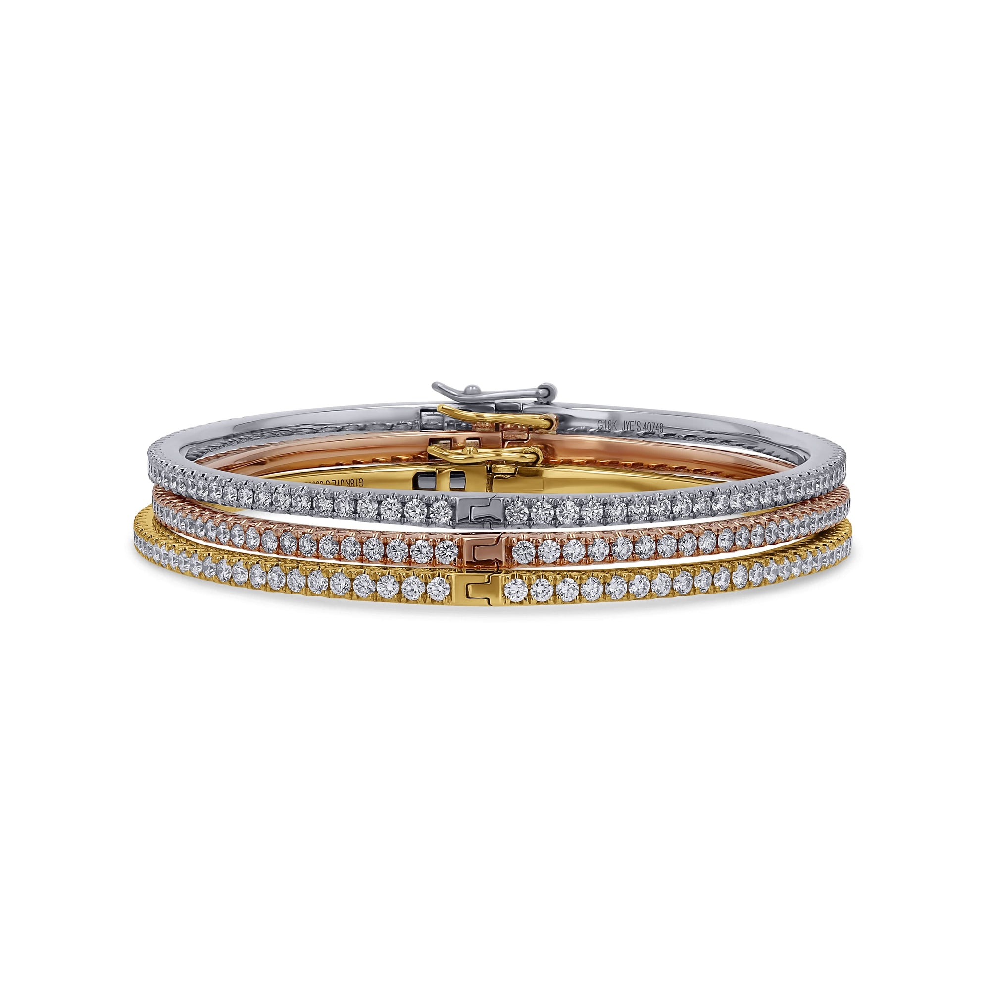 Three diamond-studded bangles in gold, silver, and rose gold on a white background