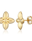 A pair of gold flower stud earrings, one shown from the front and the other from the side/back, on a clean white background with a subtle reflection.