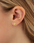 Gold earring worn by a person with blonde hair.