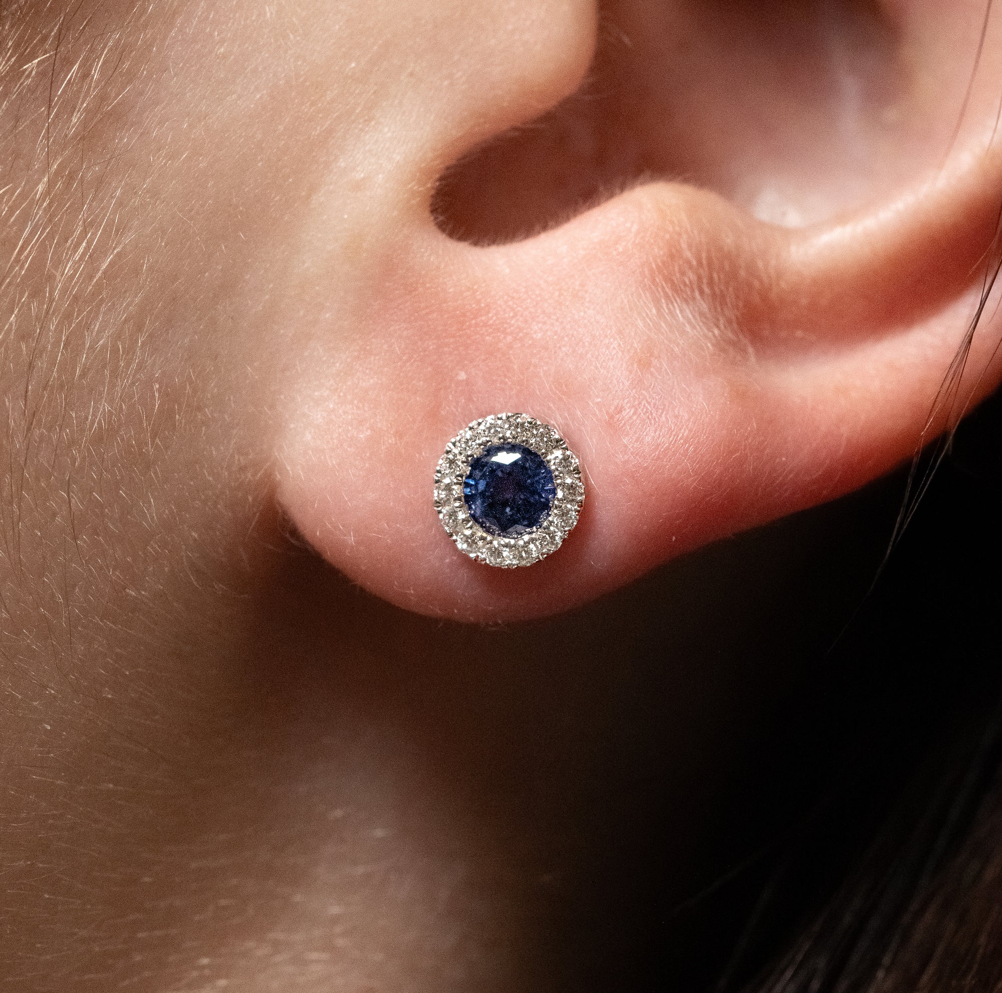 modeled image of blue sapphire stud with a diamond halo.