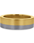 A 7mm two-tone gold wedding band by Skeie's Jewelers, featuring a horizontally split design of 14k yellow gold on the top half and 14k white gold on the bottom half, both finished with a brushed satin texture.