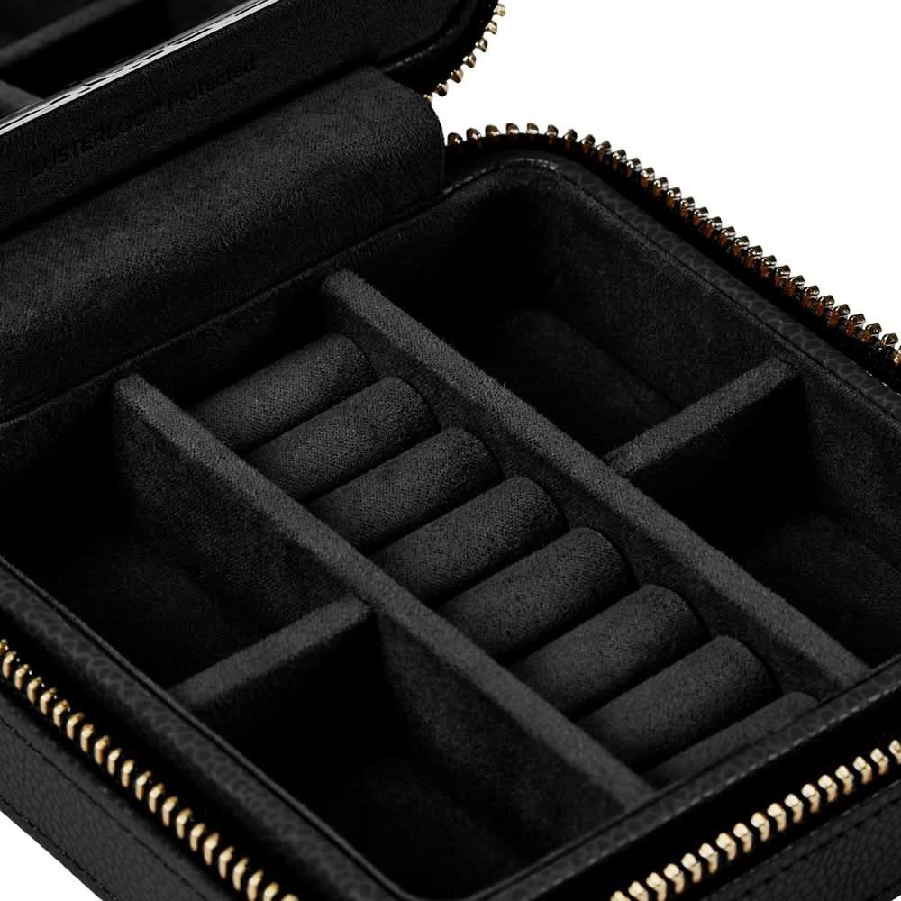 Black zippered jewelry organizer case with interior roll compartments and gold-tone zipper, shown open on a white background.