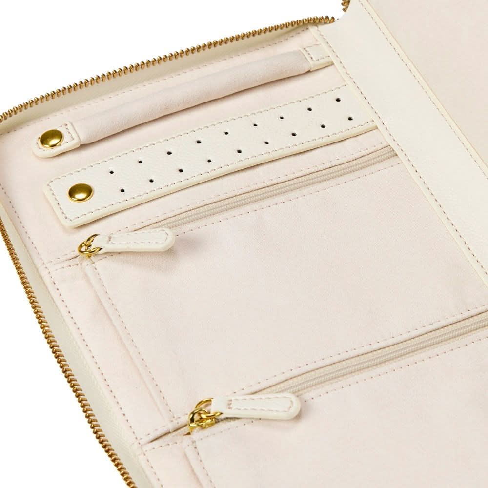 Close-up of a pale blush pink zip-around organizer or clutch with multiple interior zip compartments, a perforated detail strip, and gold-tone hardware.